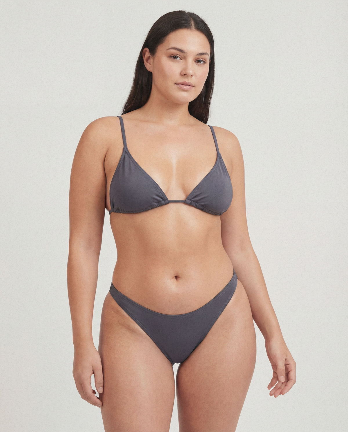 Woman wearing a gray bikini on a plain background