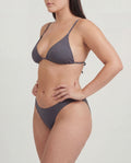 Woman wearing a gray bikini on a plain background