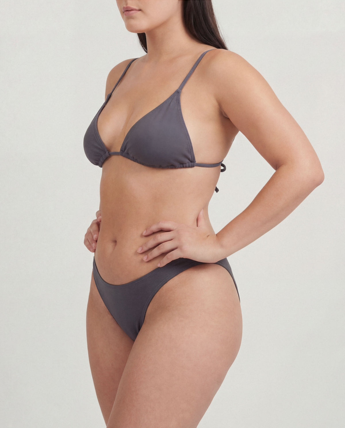Woman wearing a gray bikini on a plain background