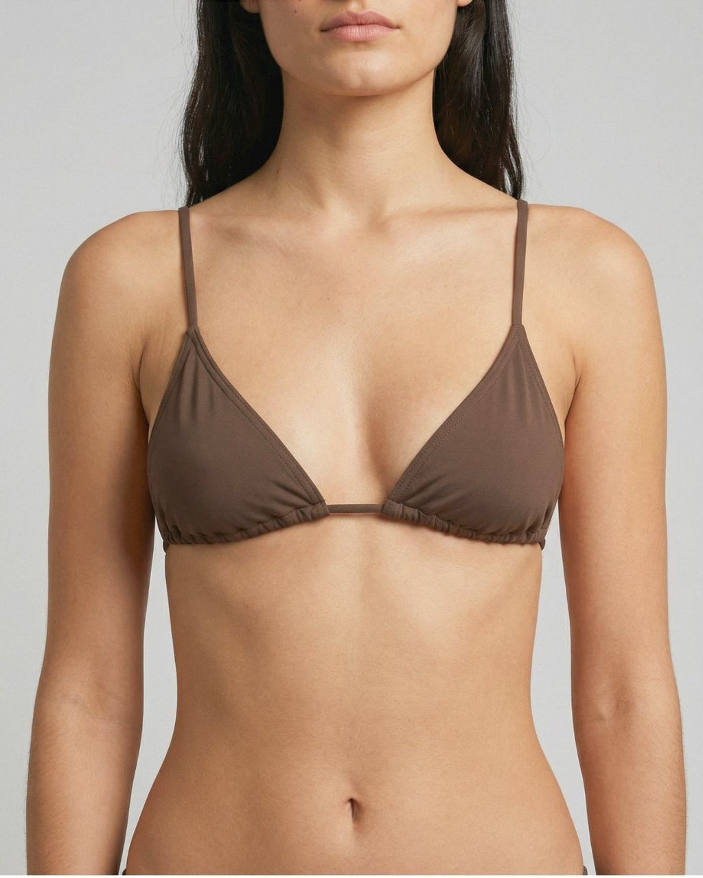 Brown bra worn by a model on a plain background