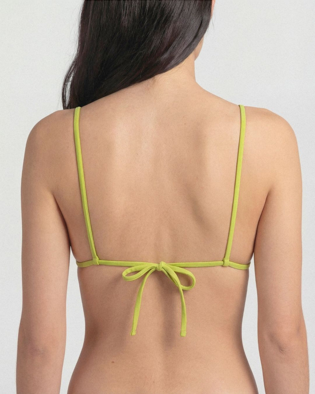 Green bikini top on a plain background