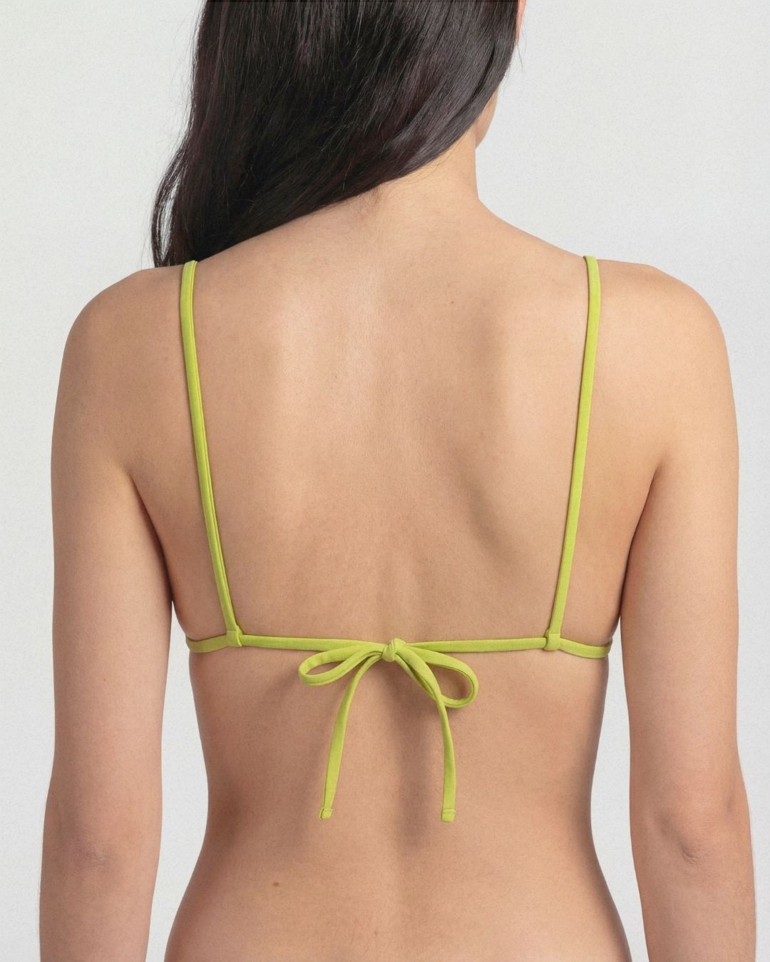 Green bikini top on a plain background