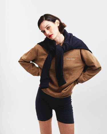 Girl posing wearing masara cacao sweatshirt and navy blue wrapped around her shoulders