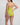 Woman wearing a lime green swimsuit on a light gray background