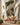 Woman in a yellow swimsuit sitting on a wooden lounge chair on a patio with ocean view.