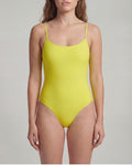 Woman wearing a yellow swimsuit against a plain background
