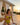 Woman in a yellow swimsuit holding a glass of wine by a poolside at sunset.