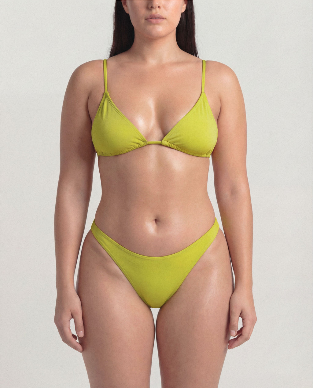Woman wearing a green bikini against a plain background