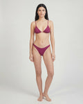 Woman wearing a purple bikini on a white background