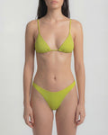 Woman wearing a green bikini against a plain background