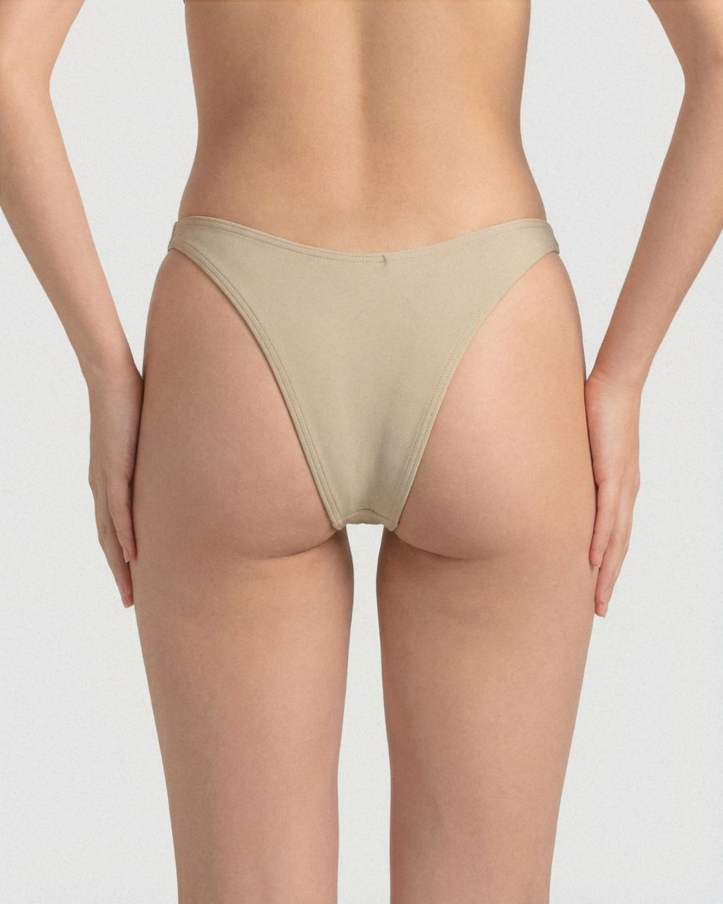Beige underwear worn by a person on a plain background