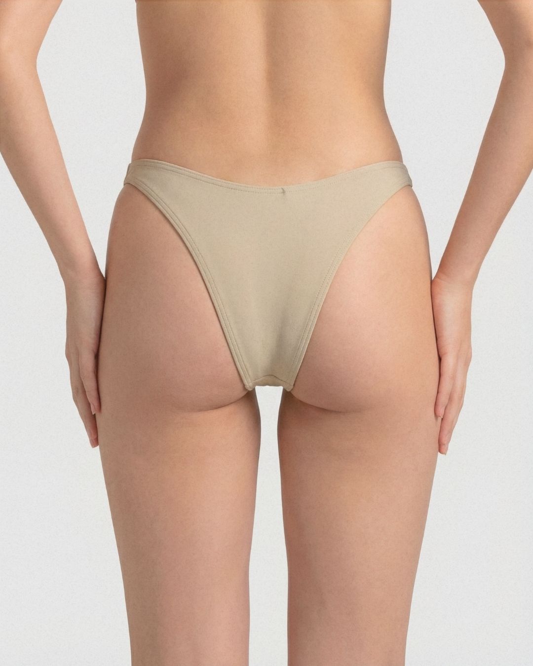 Beige underwear worn by a person on a plain background