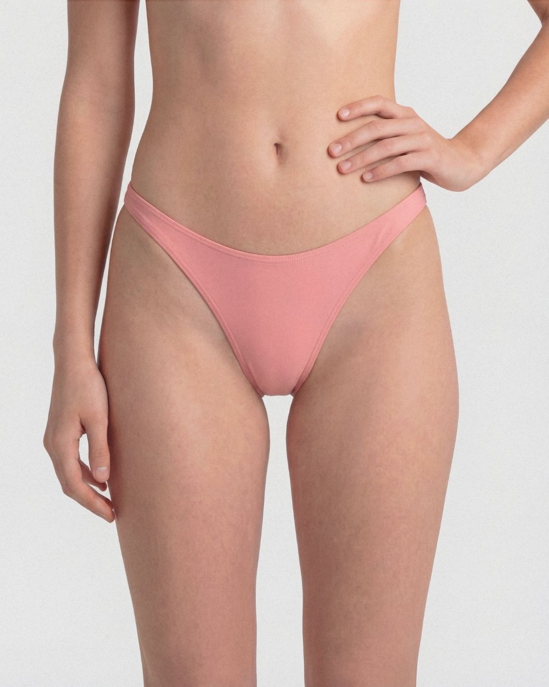 Person wearing a pink bikini bottom on a plain background