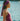 Woman in a pink swimsuit and headscarf by a body of water