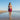 Woman in a purple bikini standing on a beach with clear blue sky