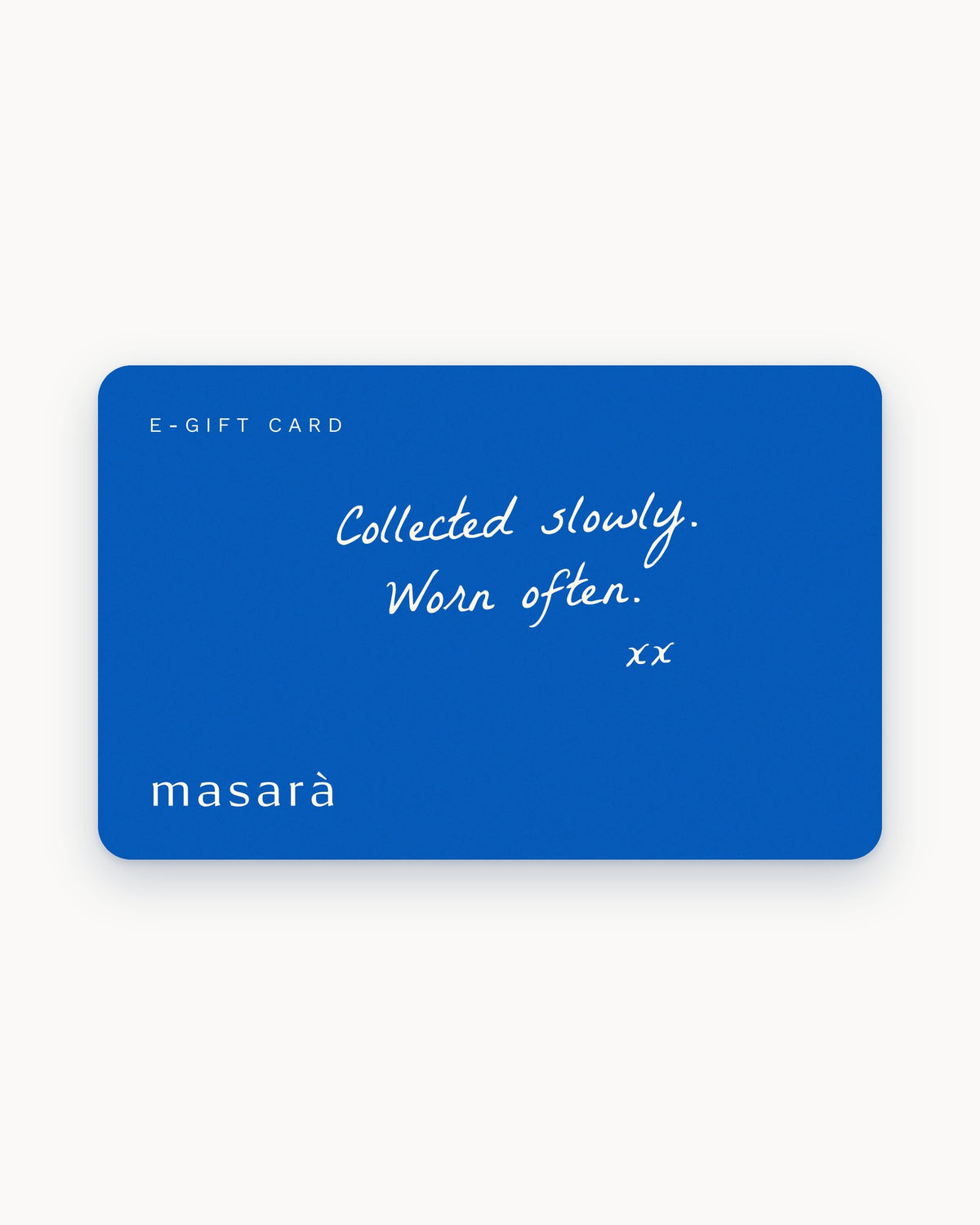 A blue Masara e-gift card with white text reading 'E-GIFT CARD', 'Collected slowly. Worn often.