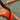 A woman wearing a bright orange one-piece swimsuit floating in clear, sunlit shallow water.