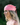 Woman wearing a pink headscarf with a blurred green background