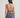 Woman wearing a brown halter top and blue jeans on a plain background