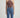Person wearing a brown halter top and blue jeans on a light gray background