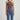 Person wearing a brown halter top and blue jeans on a light gray background