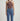 Person wearing a brown halter top and blue jeans on a light gray background