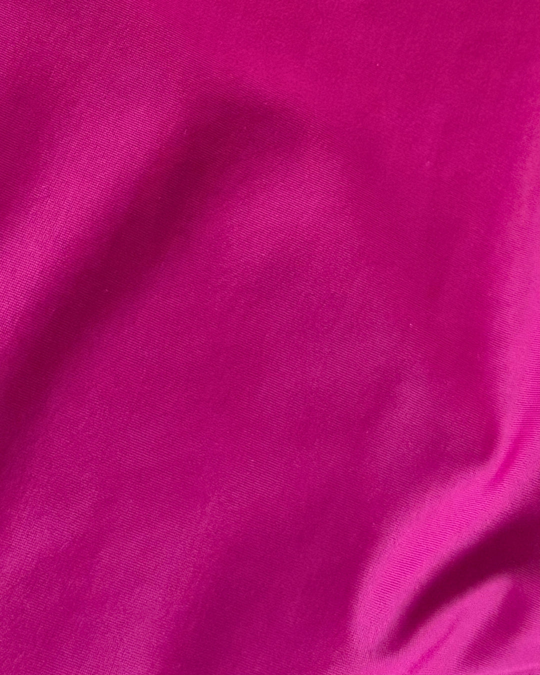 Close-up of bright pink regenerated nylon  fabric with a slight texture