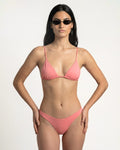 Woman wearing a pink bikini on a white background